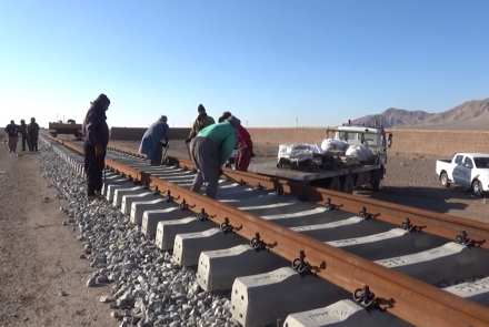 Workers are working on the railway track.