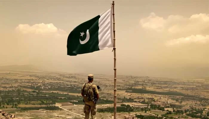 Still from ISPR’s Pakistan Defence Day 2025 video shows a soldier facing the horizon as the Pakistani flag flies proudly above him. [Courtesy: ISPR].