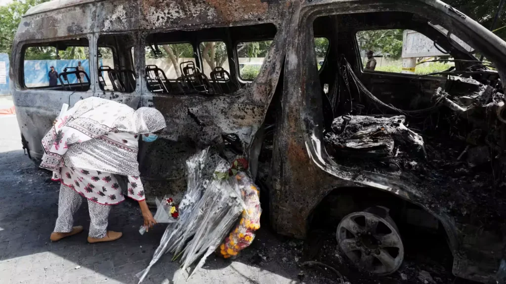 A student lays a bouquet in memory of her Chinese teachers, near the wreckage of a passenger van after a blast, during what they call a peaceful protest, outside the Confucius Institute at University of Karachi, in Pakistan. [IC: Reuters]