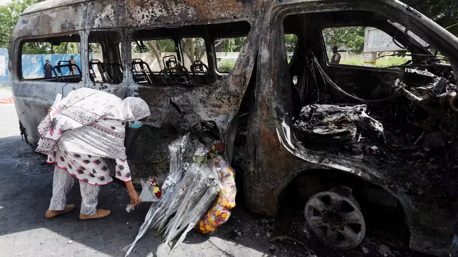 A student lays a bouquet in memory of her Chinese teachers, near the wreckage of a passenger van after a blast, during what they call a peaceful protest, outside the Confucius Institute at University of Karachi, in Pakistan. [IC: Reuters]