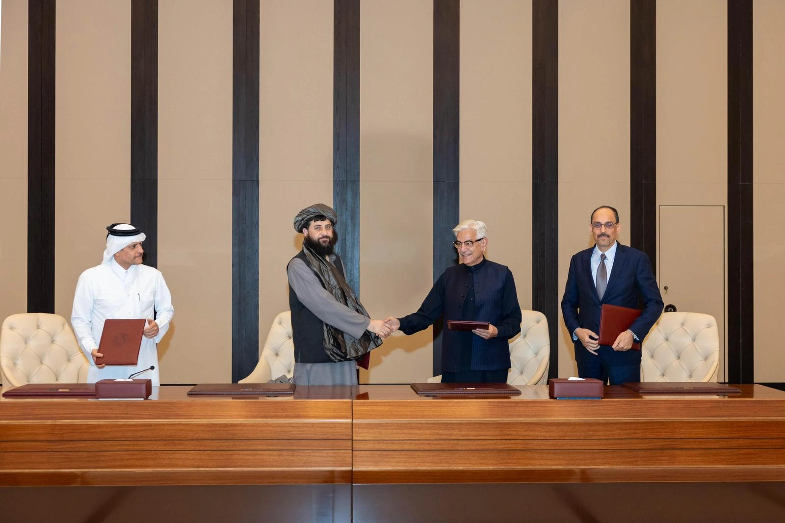 Afghan Defence Minister Maulvi Sahib Muhammad Yaqub Mujahid (centre left) shakes hands with his Pakistani counterpart Khawaja Asif after the two sides agreed to a ceasefire on Sunday, October 19 in Doha, Qatar. — X/@MofaQatar_EN