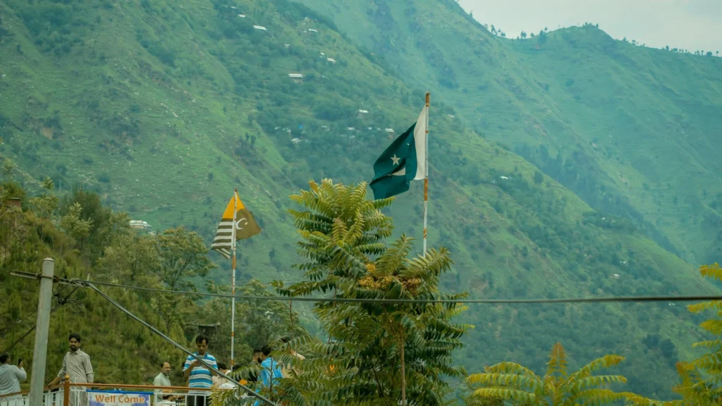 Pakistani and Azad Kashmir flags wave against the lush green hills of Kashmir amid renewed India-Pakistan tensions following the Pahalgam attack. [IC: File Photo]