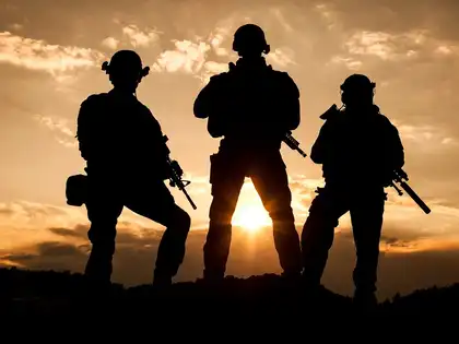 Three armed terrorists with pistols standing facing the sunset