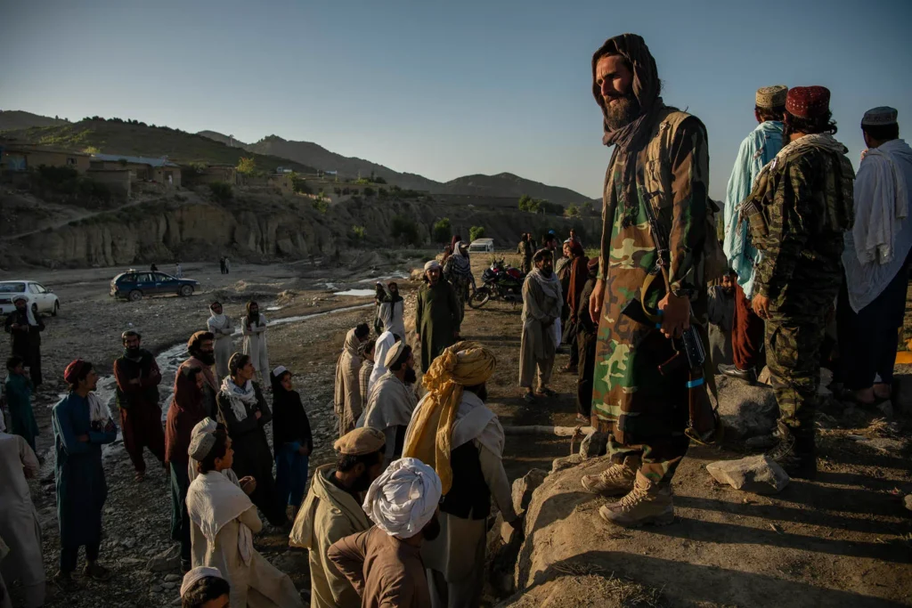 Taliban fighters guard an aid site and give instructions to survivors of the earthquake, in the Gayan district of Afghanistan, June 24, 2022. [IC: Kiana Hayeri/The New York Times]