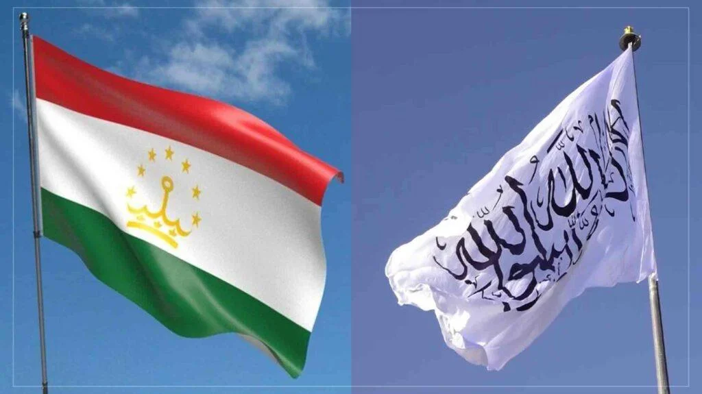 Tajikistan’s flag with red, white, green stripes and a gold crown, and the white Taliban flag with black Arabic script.