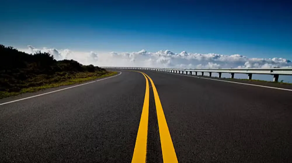 A scenic view of a highway cutting through mountains, representing the N 15 Highway upgrade from Mansehra to Chilas. IC: ProPakistani